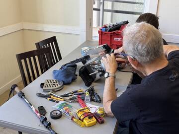 A visitor working on an espresso machine surrounded by tools